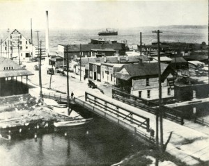 Overview of the north Union Street bridge over the Boardman River taken from the tower of the Traverse City State bank. Steamer ”Puritan” on the bay, ca. 1910-20. Image courtesy of Traverse Area District Library, Local History Collection.